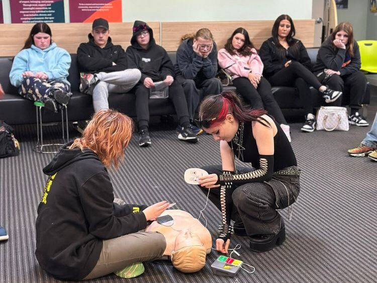 2 students working on first aid dummy