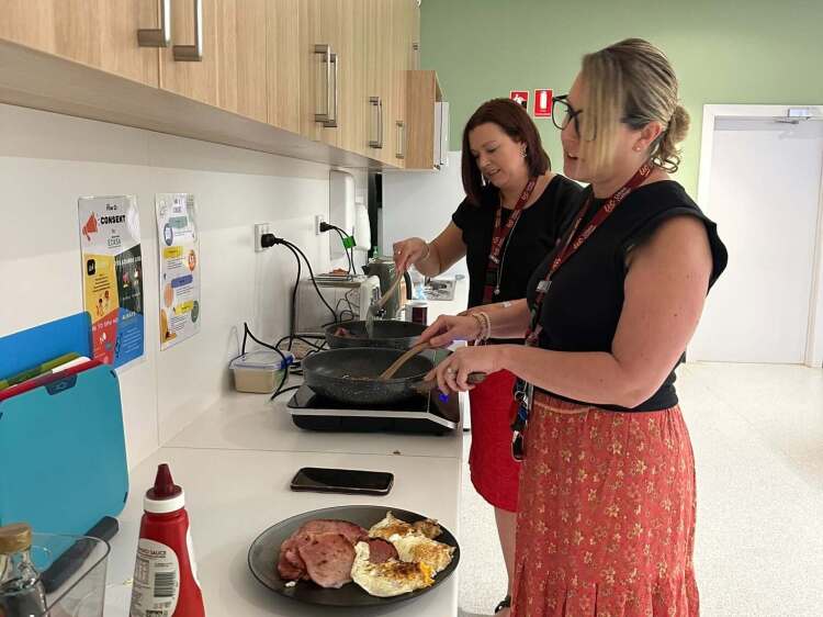 2 teachers cooking bacon & eggs breakfast