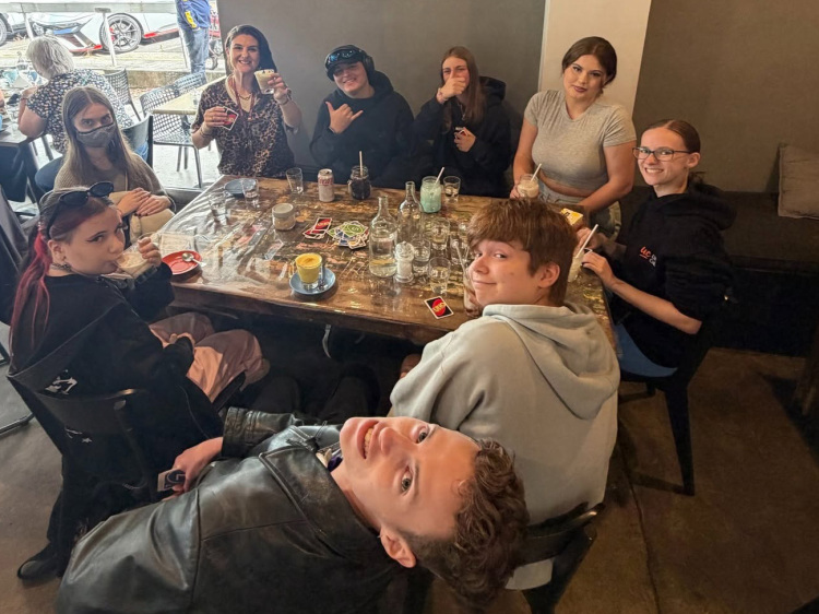 group of students sitting around a table at a cafe