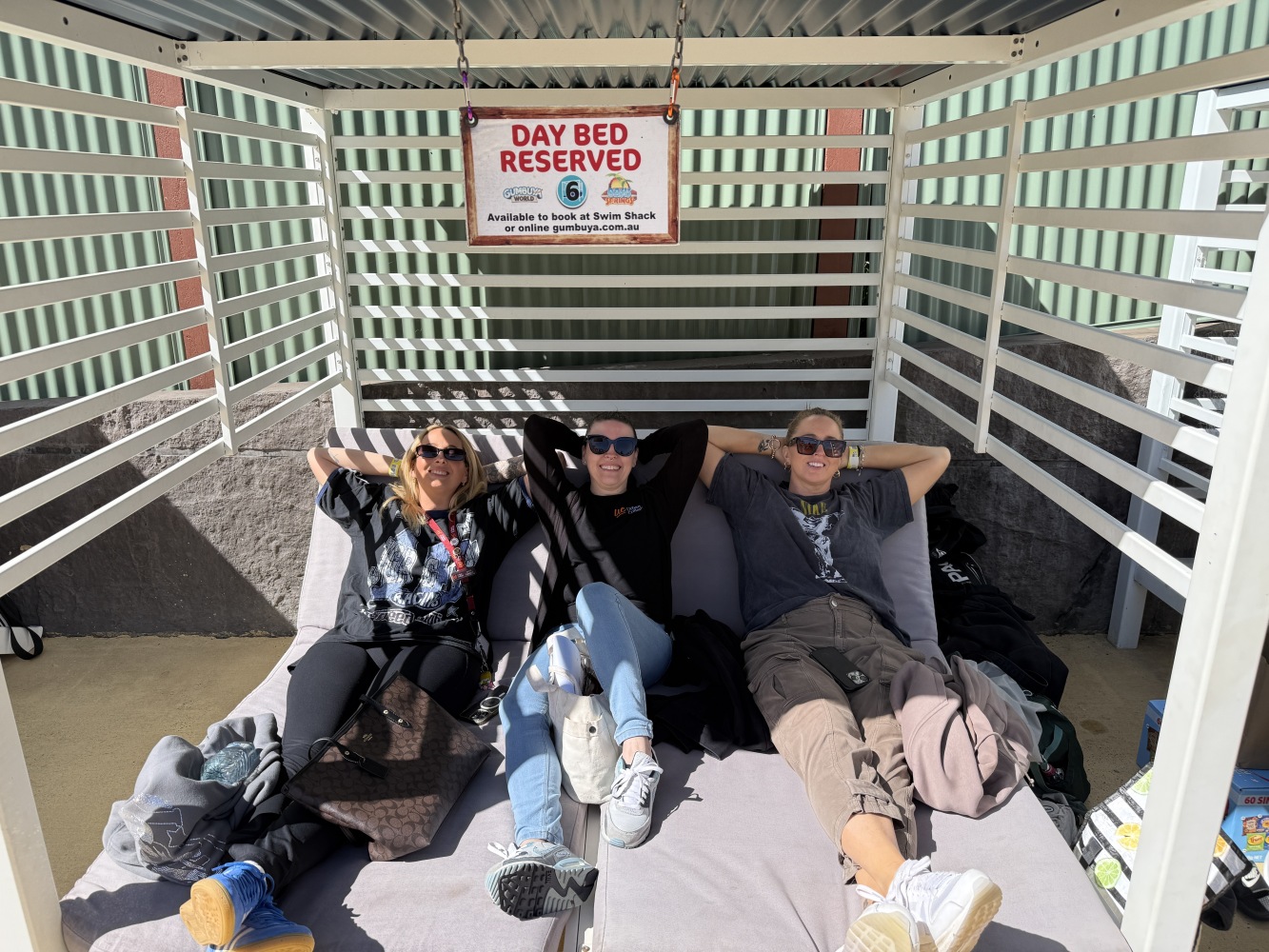 3 staff sitting on day bed relxing