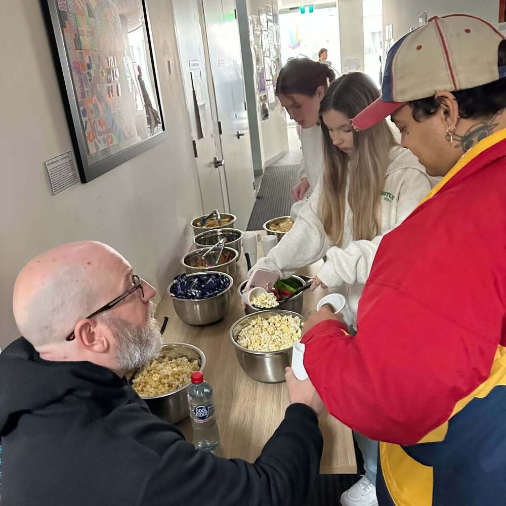 students topping up their popcorn and candy for some movie fun