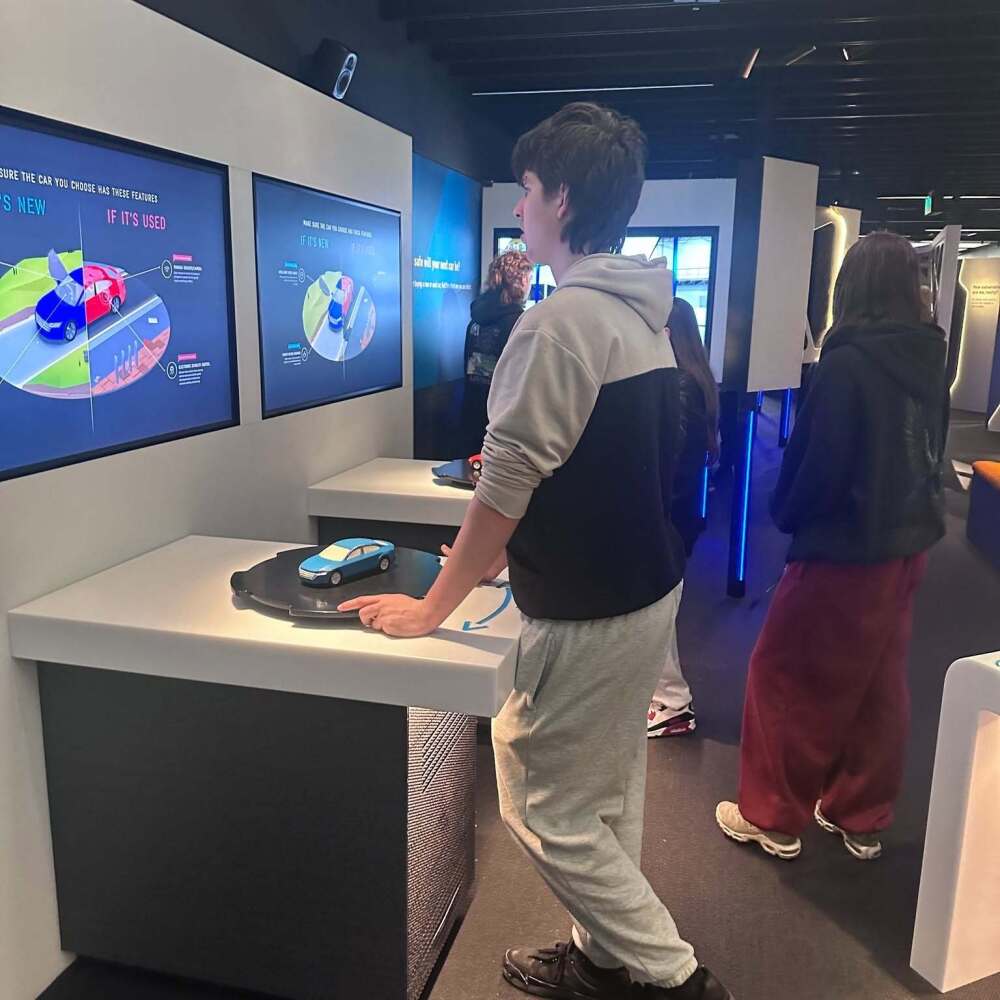 Urban College students exploring an interactive vehicle and road safety exhibit