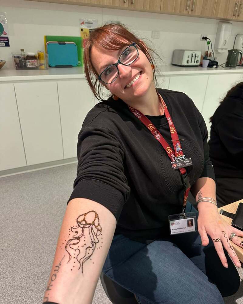 teacher proudly showing her henna design on her arm