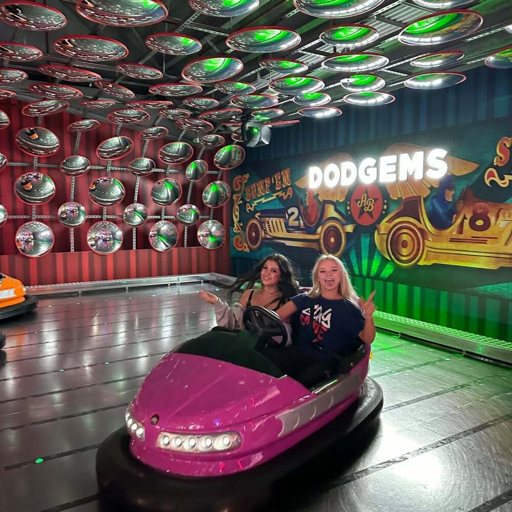 2 female students in pink dodgem car