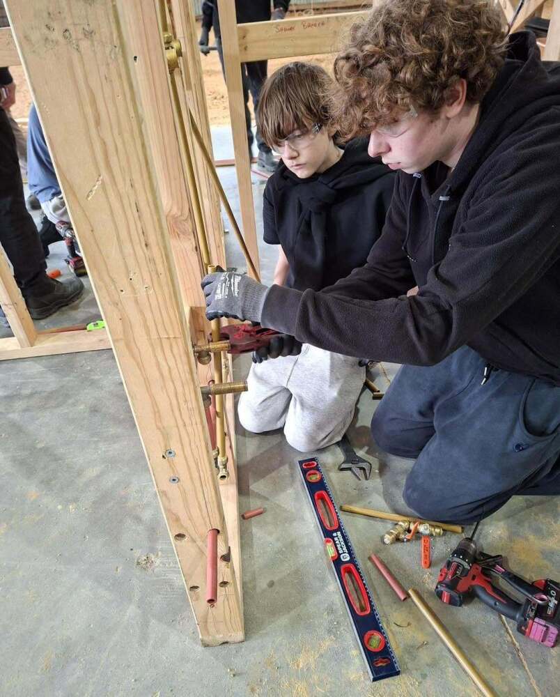 Students working on pipes in shower frame at Swinburne