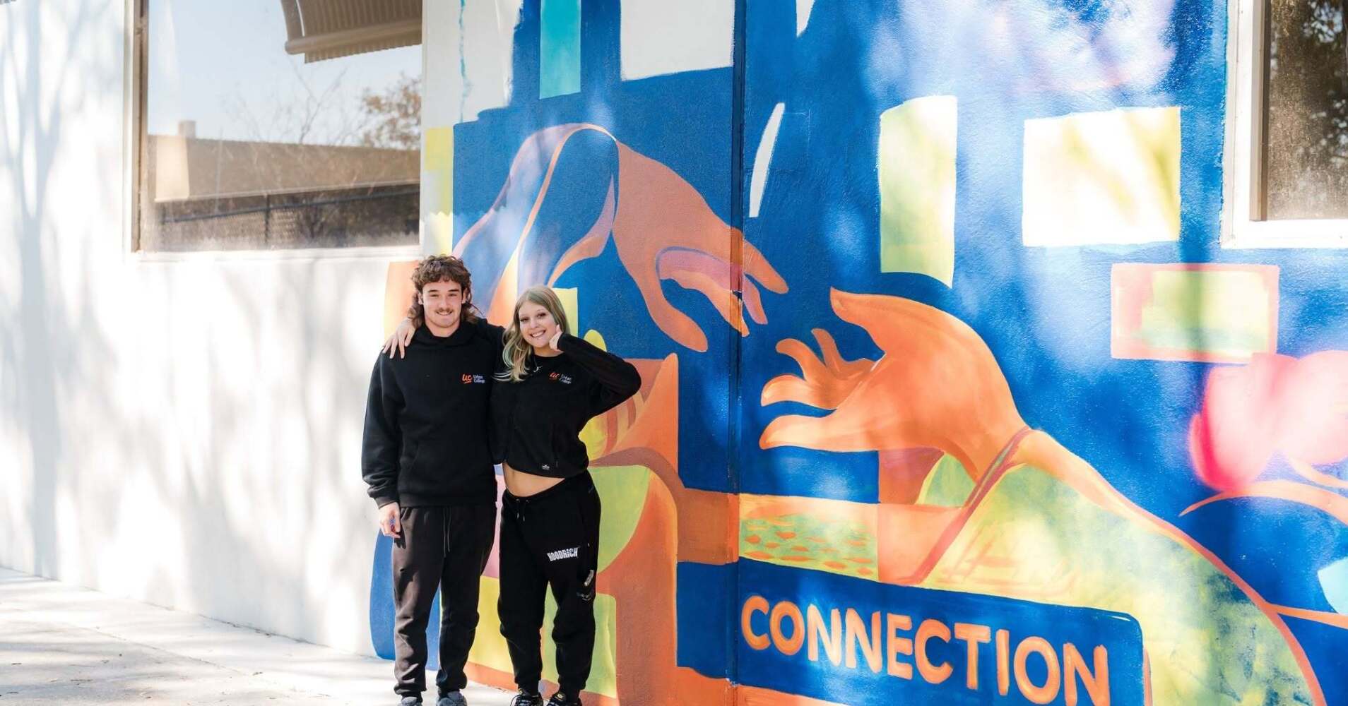 2 students standing in front of new mural