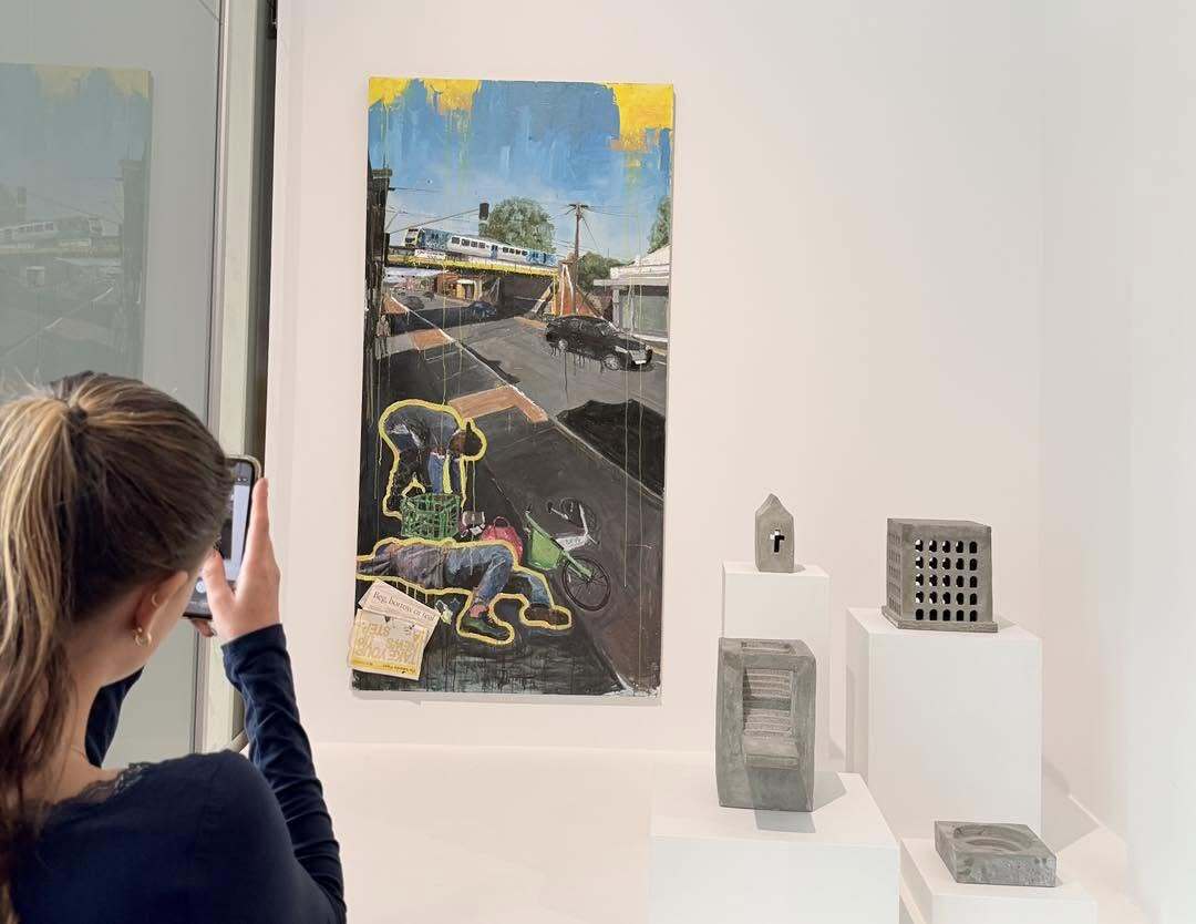 student taking photo of art on the wall
