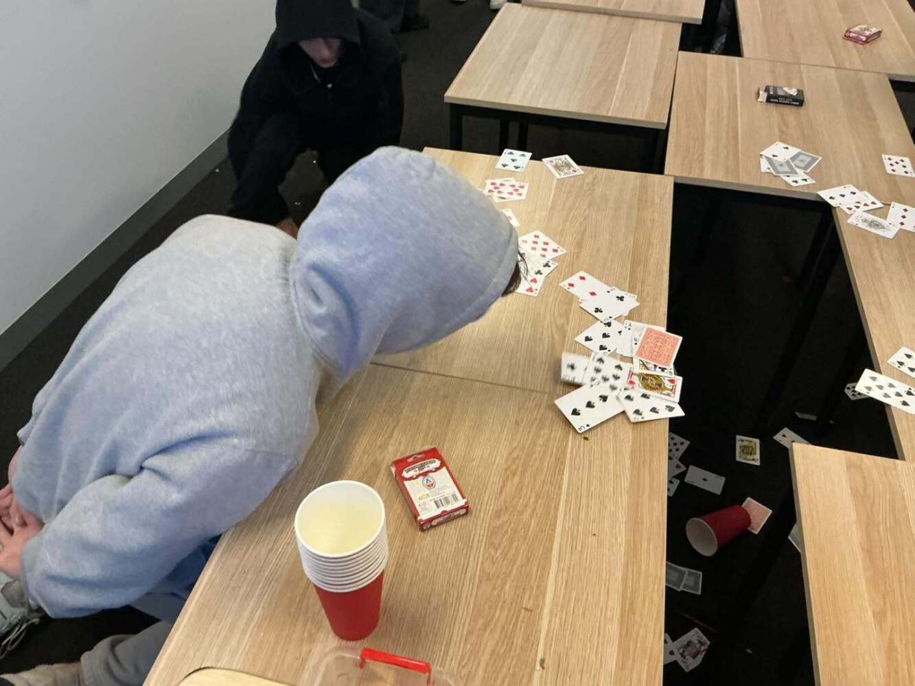 student plaing game with pack of cards