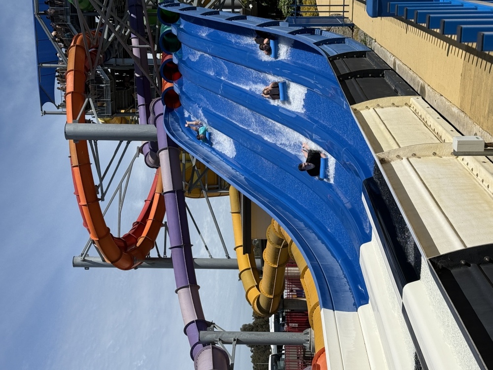 2 students racing 2 staff on water slide